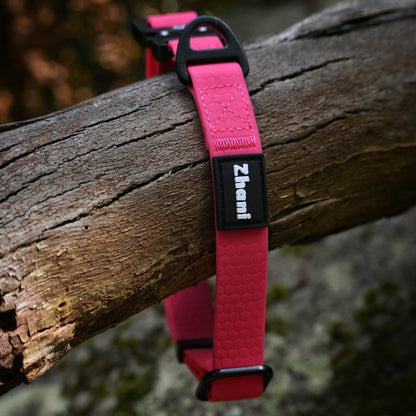 Pink dog collar with 'Zhani' branding on a wooden log.