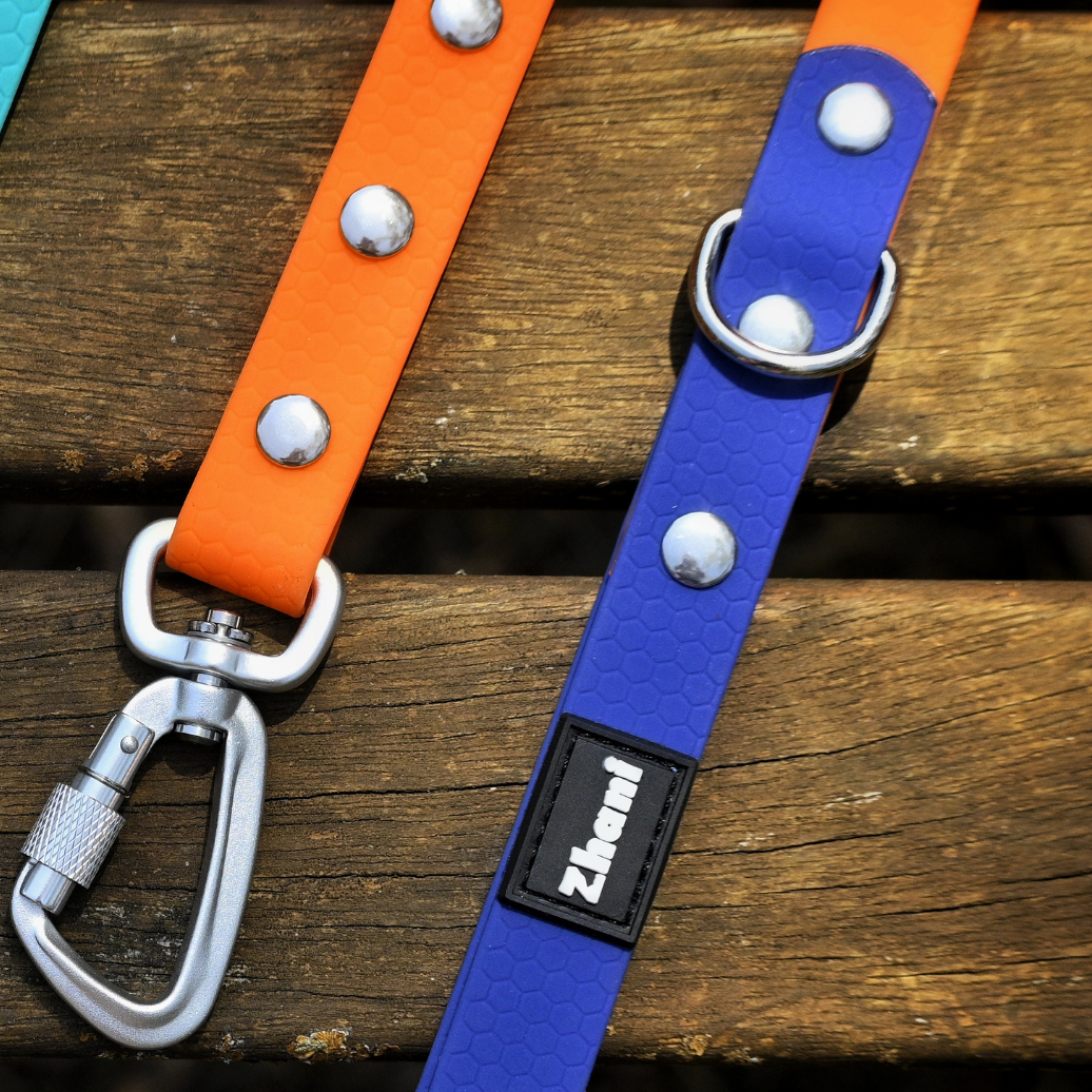 Blue and orange Zhani dog leash with carabiners on a wooden surface